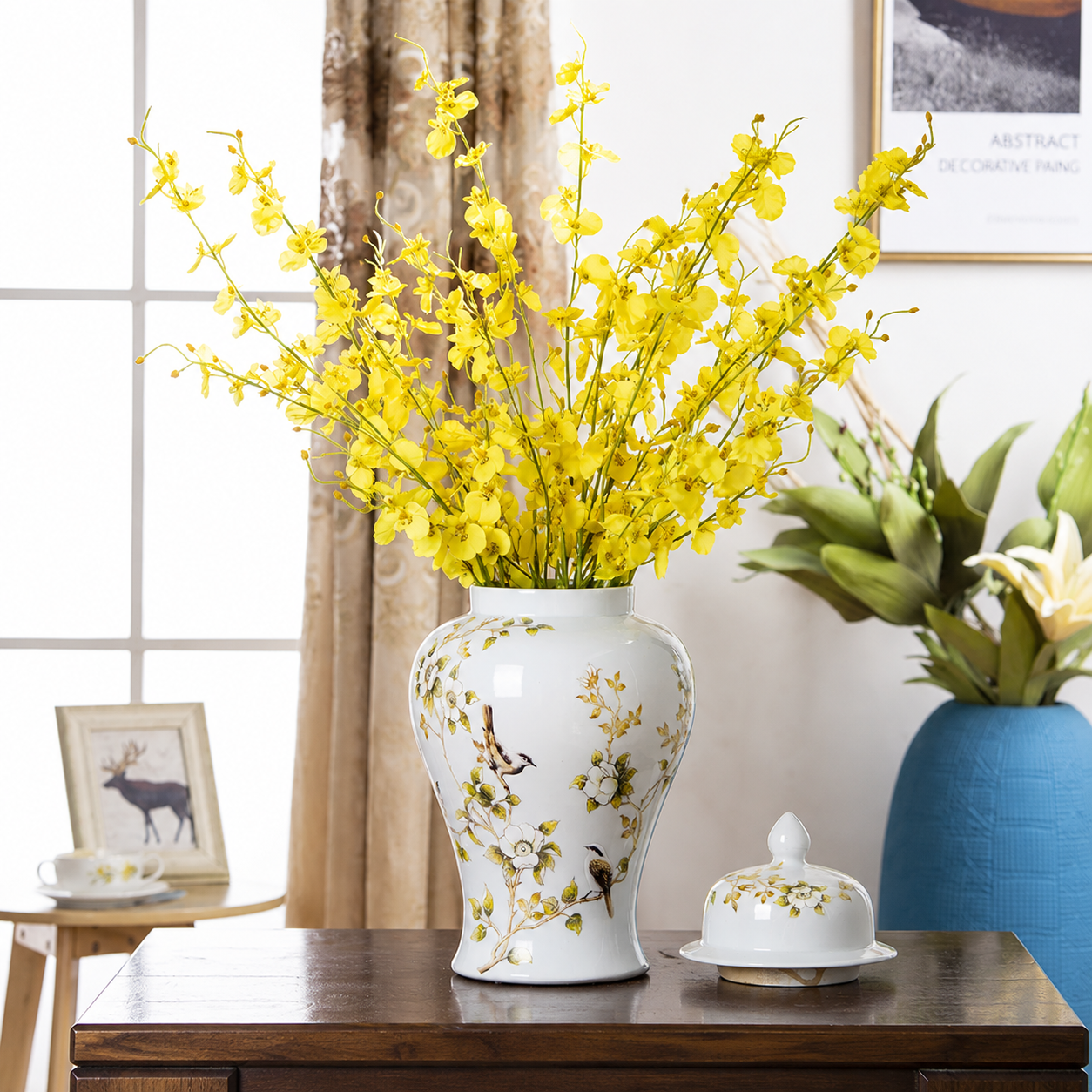 White ceramic ginger jar vase with yellow flowers and matching lid in elegant living room setting