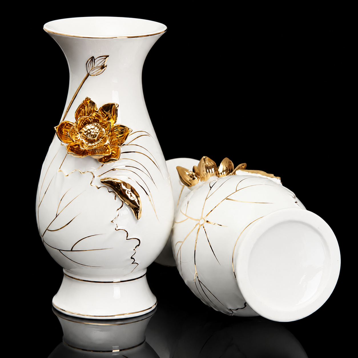 White ceramic vase with gold lotus detail shown upright and lying on side