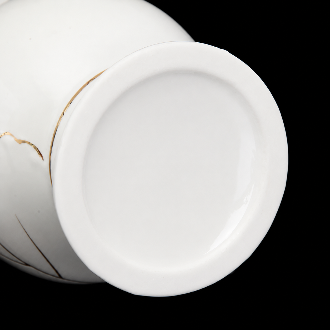 Close-up of white ceramic vase base showing smooth glossy finish