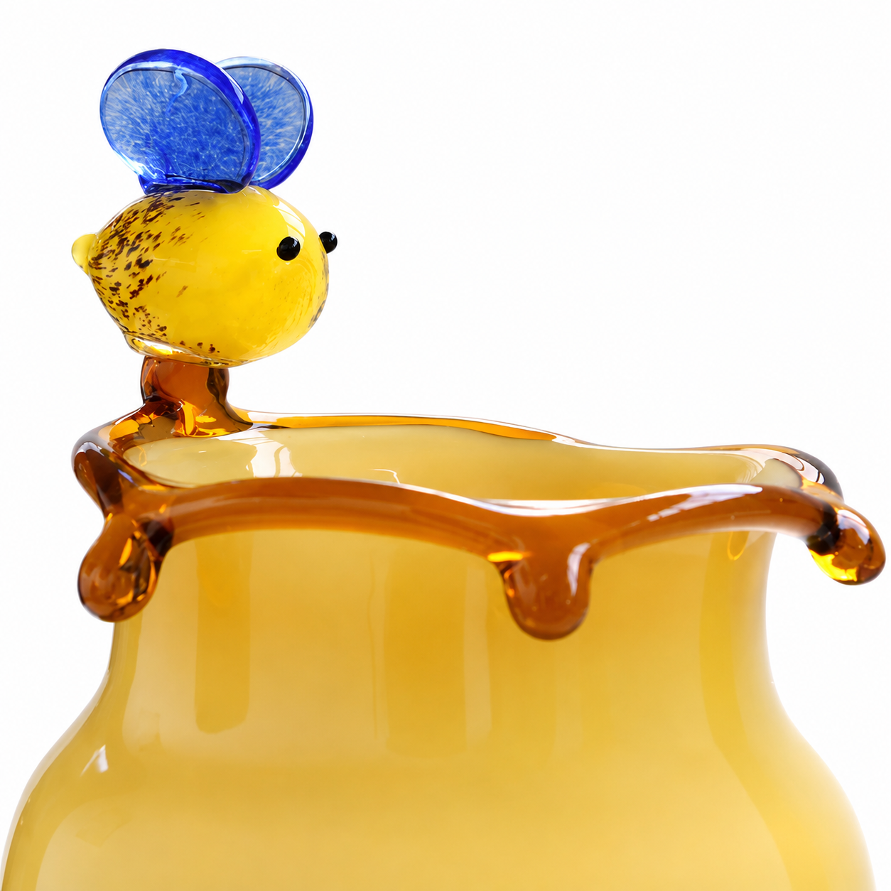 Close-up of yellow glass vase with bee accent and amber honey drip rim