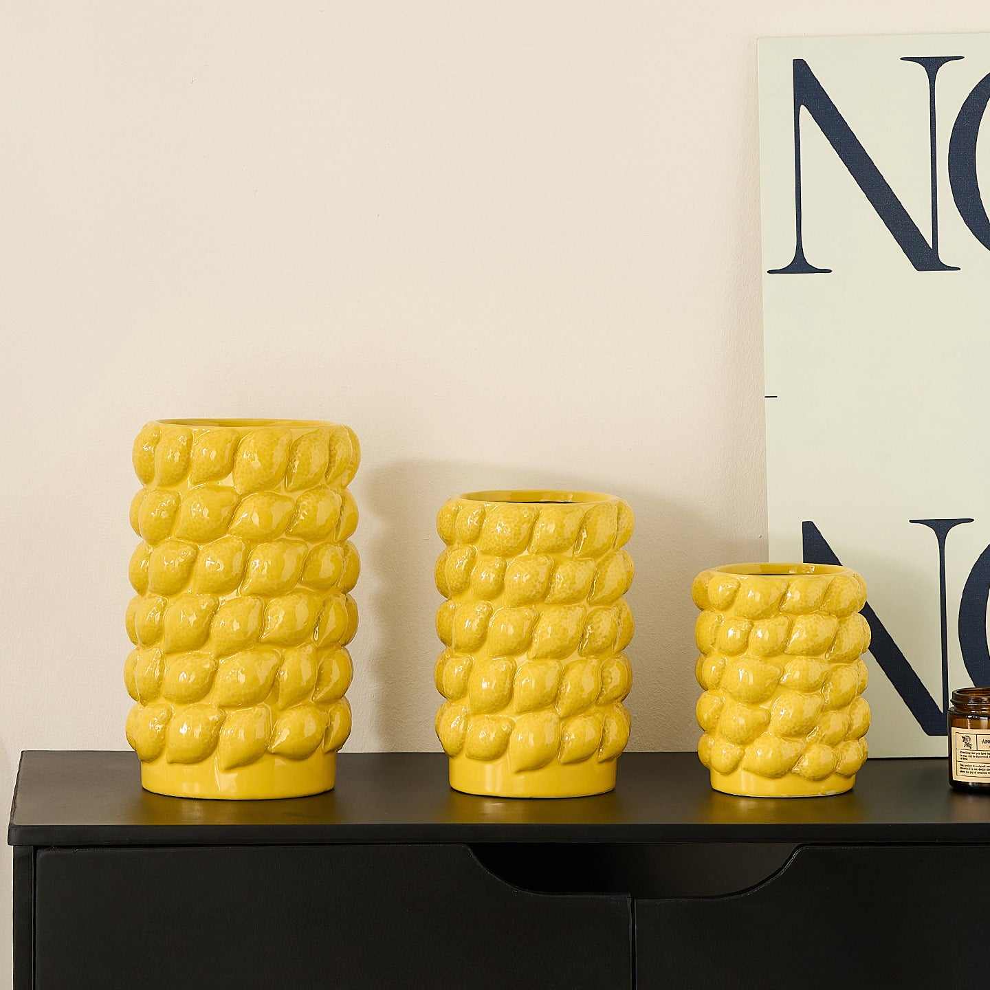 Large medium and small yellow lemon textured ceramic vases shown together for size comparison
