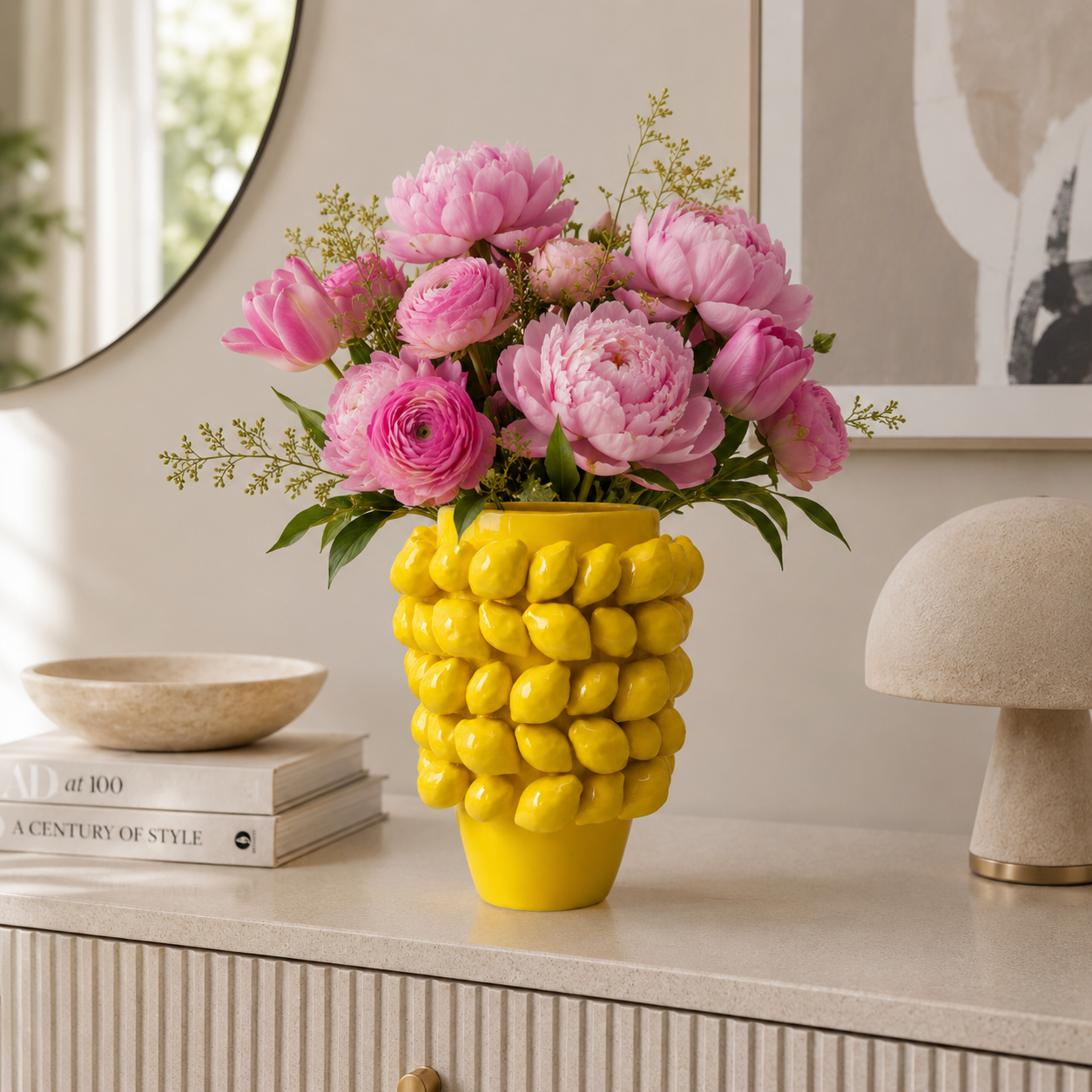 Yellow glazed ceramic lemon vase styled with pink flowers for luxury living room decor
