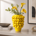 Yellow ceramic lemon textured vase styled with yellow flowers in a modern interior