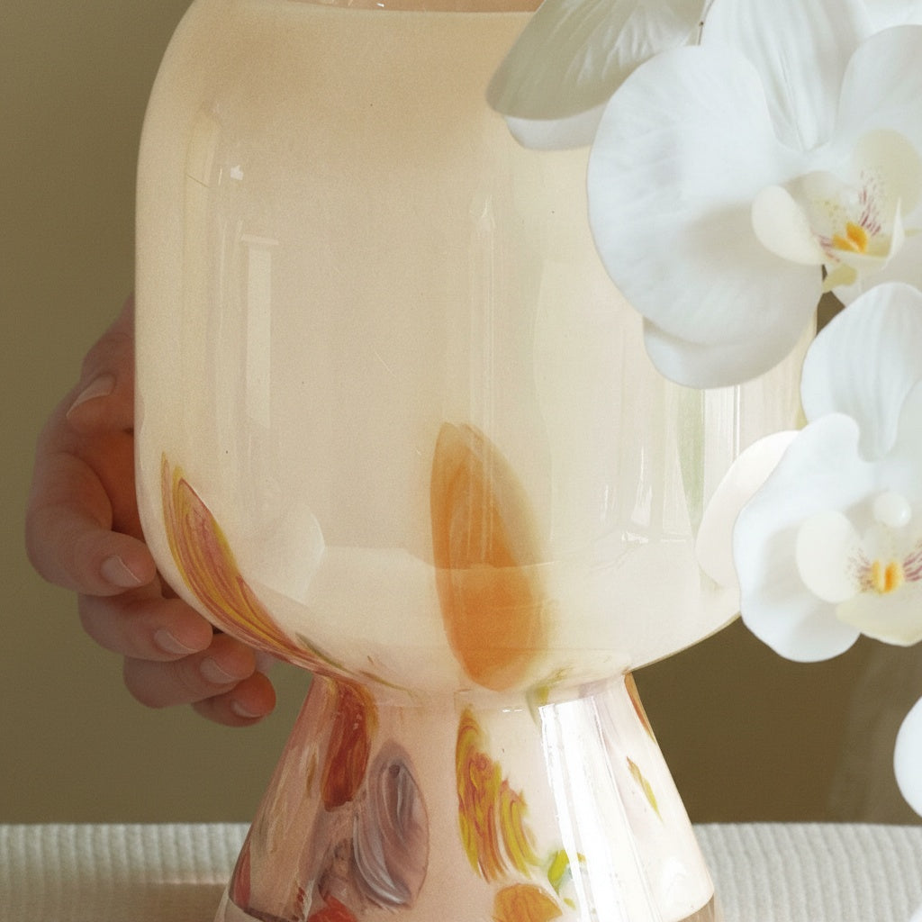 Hand holding cream abstract glass pedestal vase