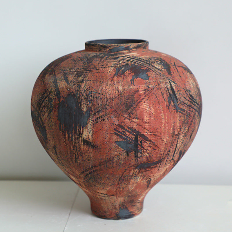 Close up of round distressed ceramic vase with abstract markings