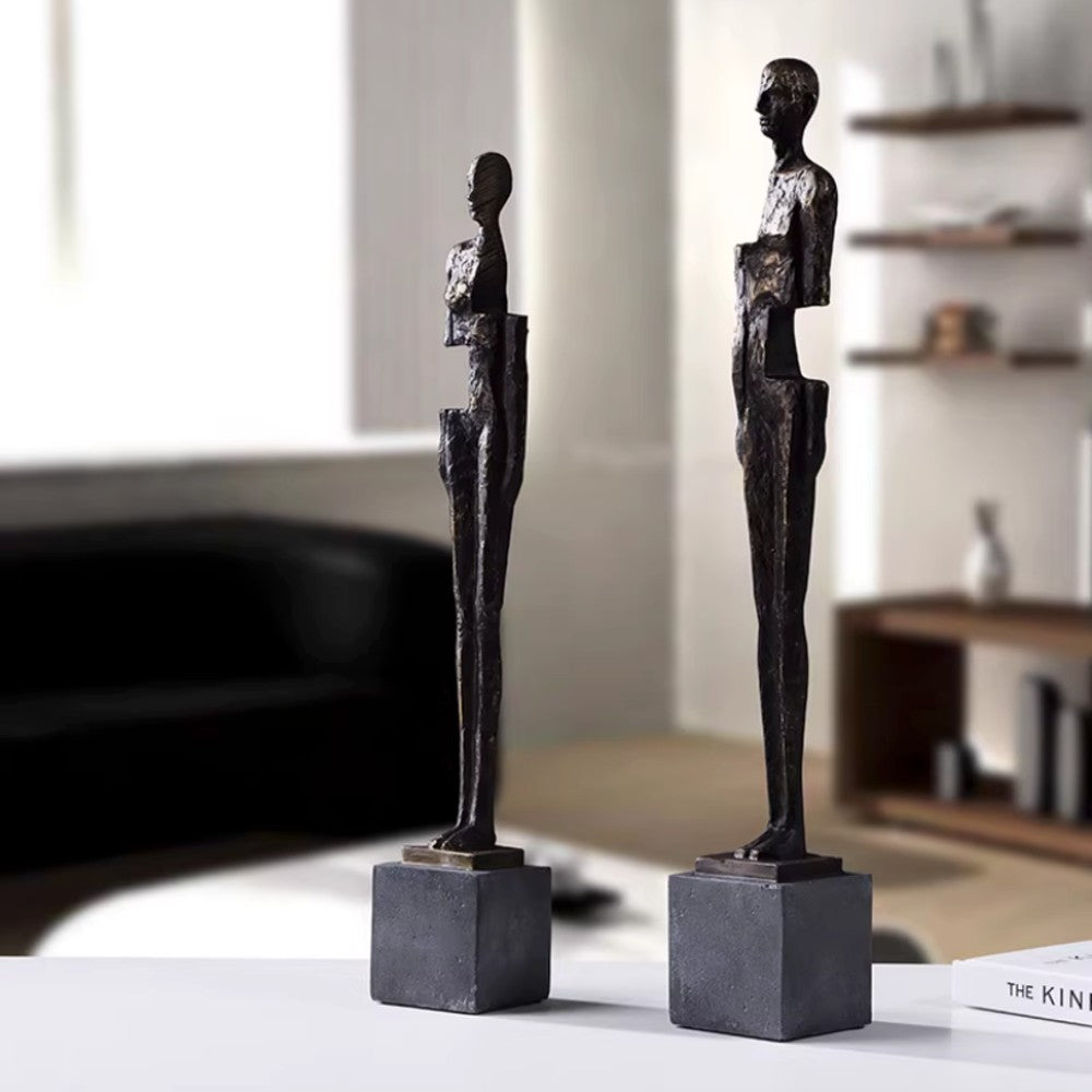 Male and female abstract resin figure sculptures styled together in a modern interior