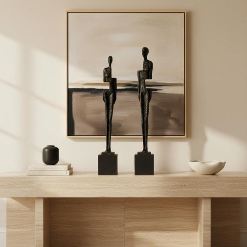 Pair of antique bronze resin abstract figure sculptures styled on a modern shelf