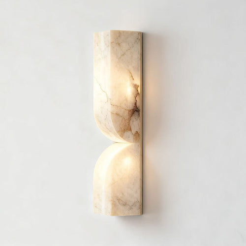 Front view of alabaster curved wall sconce with warm illumination