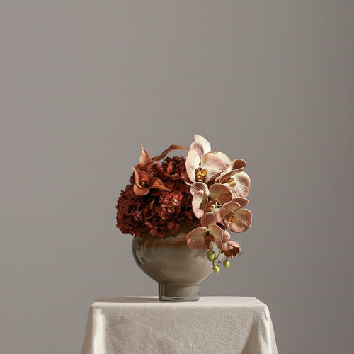 Amber and cream art glass bowl vase with floral arrangement