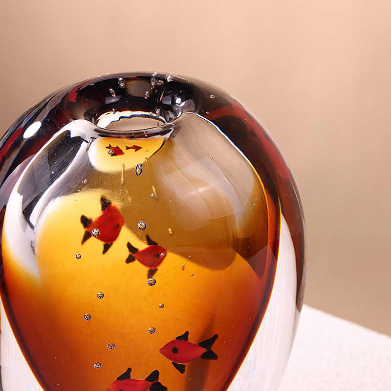 Close up detail of red fish and bubbles inside glass vase