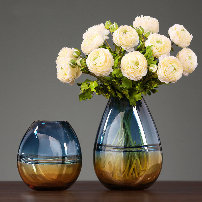 Amber and blue gradient glass vase with white ranunculus flowers