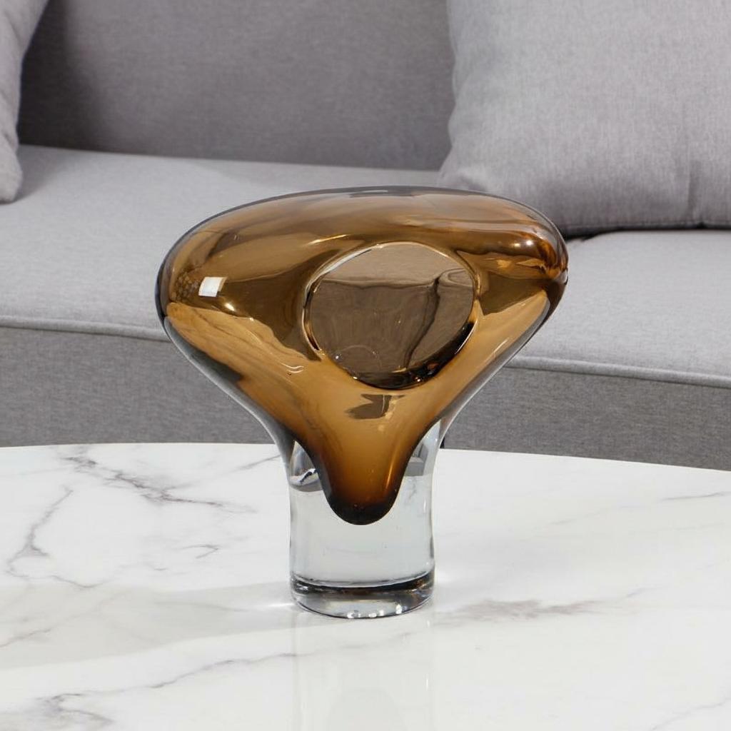 Side view of abstract amber glass vase showing fluid form