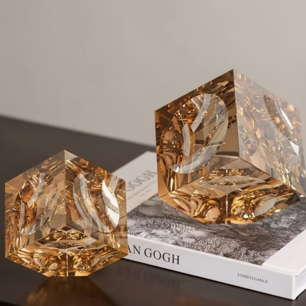 Amber crystal geometric cube paperweight on coffee table book