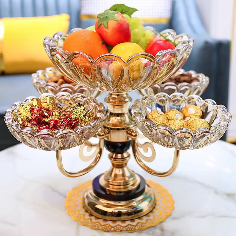 Amber crystal fruit stand filled with fresh fruit and nuts on a marble table