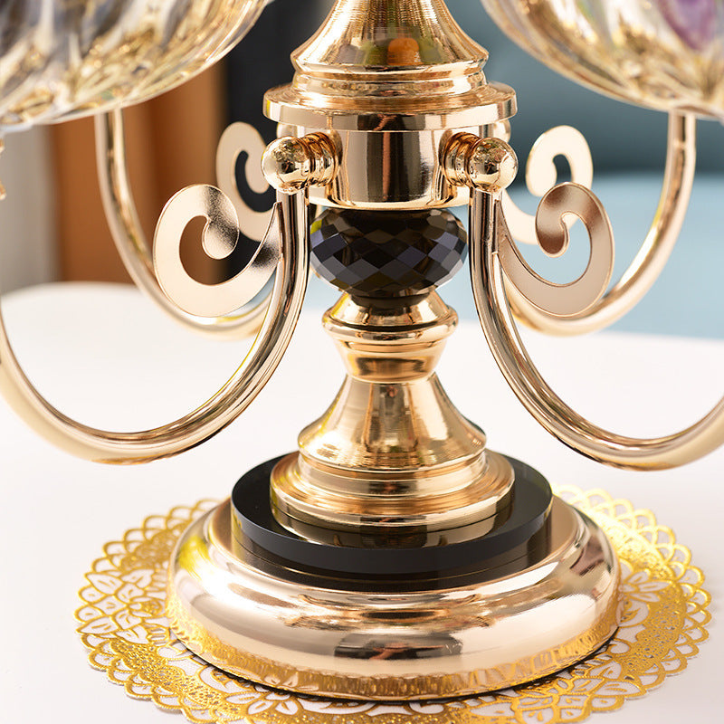 Close up detail of gold metal scroll arm and base of the fruit stand