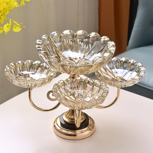 Empty amber crystal and gold four-bowl tiered stand on white surface