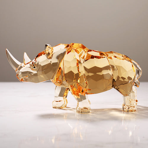 Faceted amber glass rhino figurine on marble surface