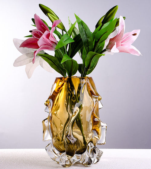 Amber crystal vase with pink lilies on table