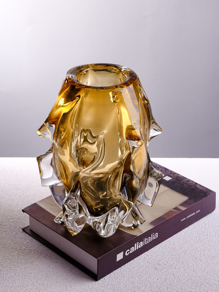 Side view of sculptural glass vase on books