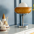 Front view of amber glass and chrome table lamp on white console
