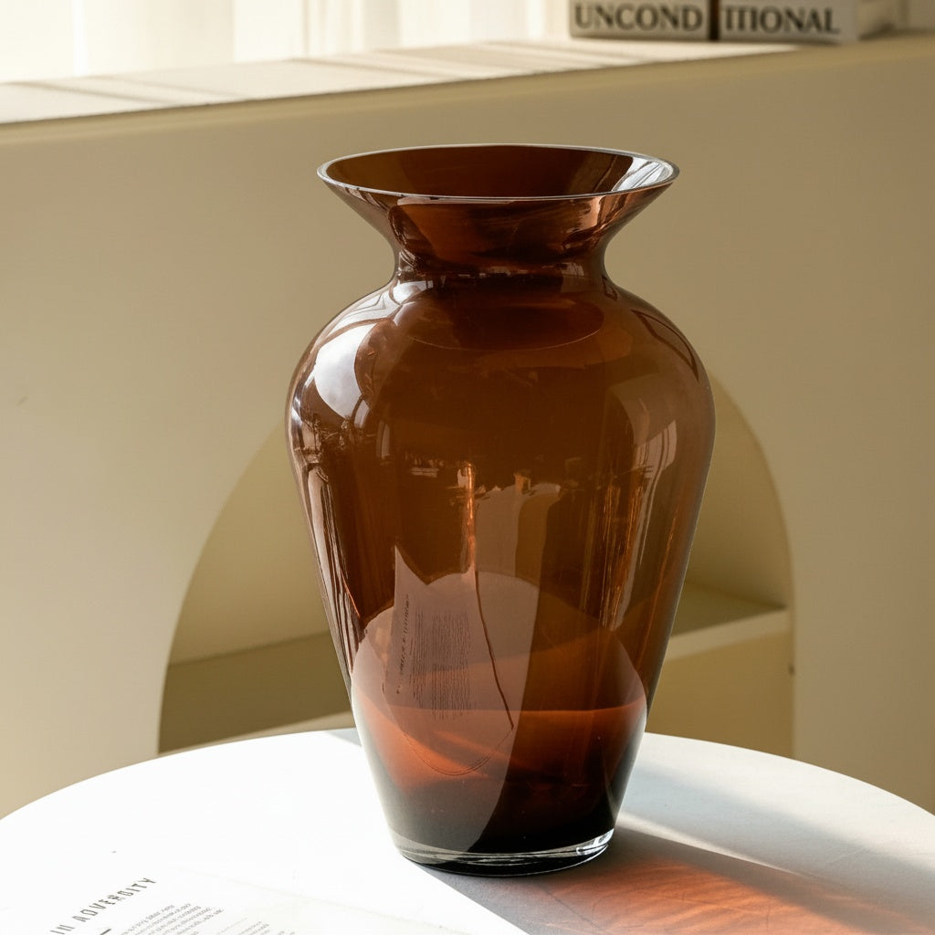 Empty amber glass flared vase on a white table