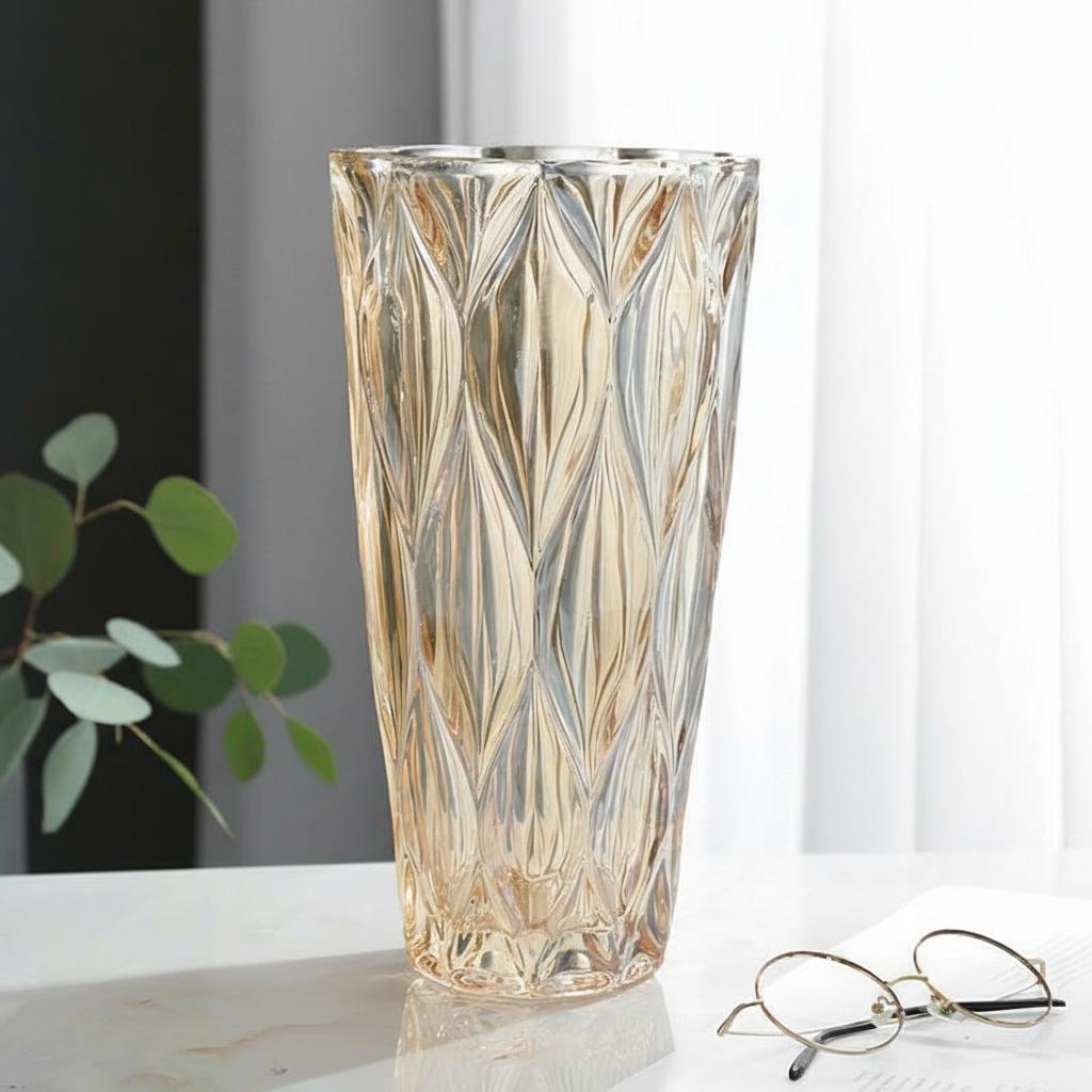 Amber glass geometric faceted vase on marble table with glasses