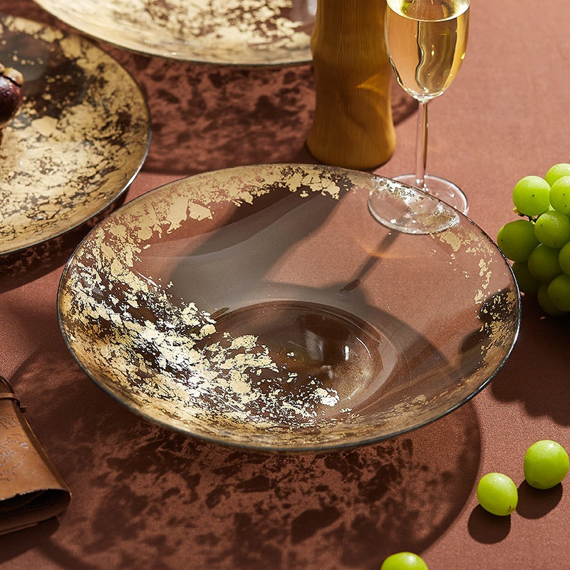 Amber glass serving bowl with gold leaf details on table