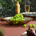 Side profile of gold leaf glass bowl filled with fruit