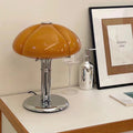 Amber glass pumpkin shade table lamp with chrome base on white surface