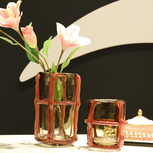 Two amber glass caged vases styled with lilies