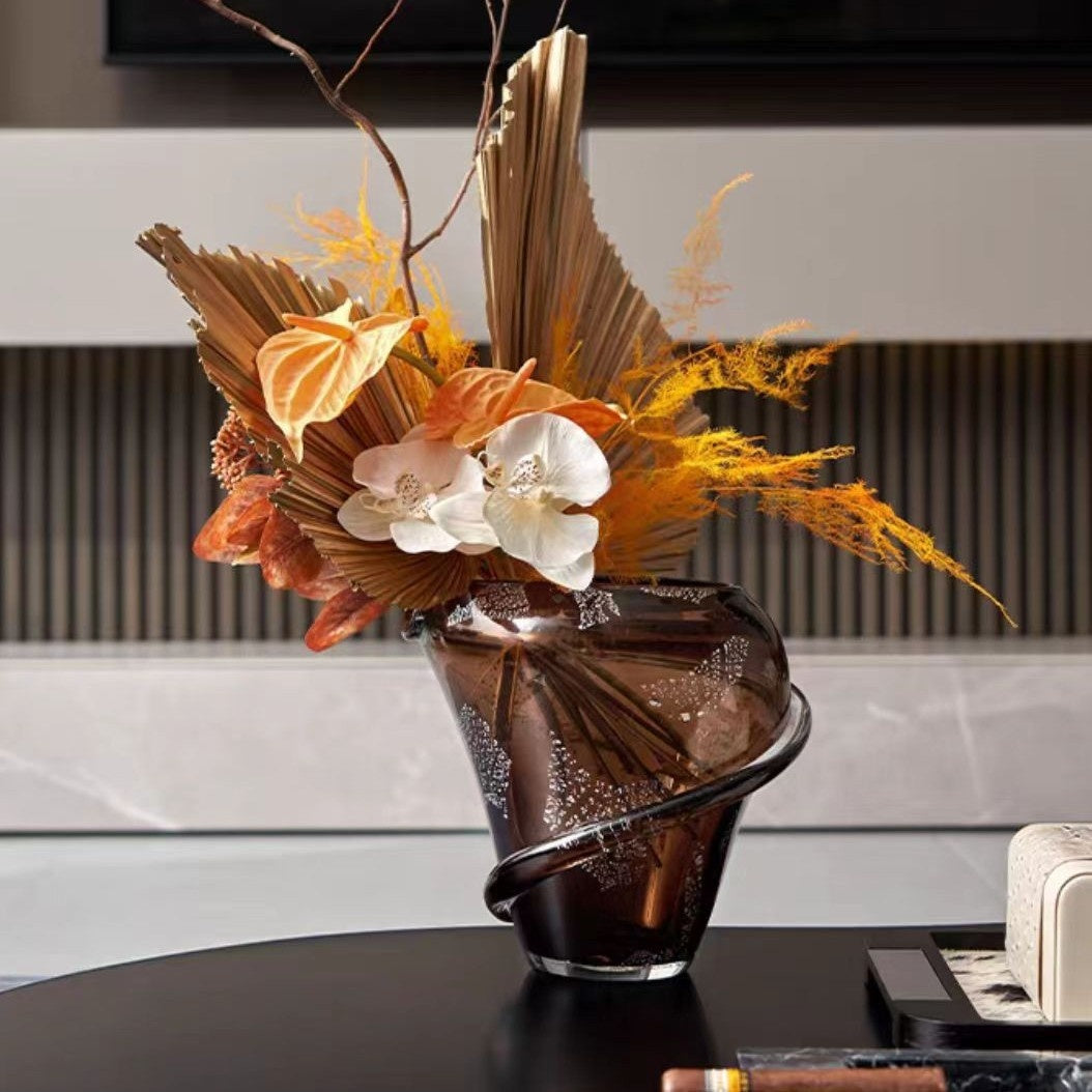 Styling detail of amber spiral vase with floral arrangement