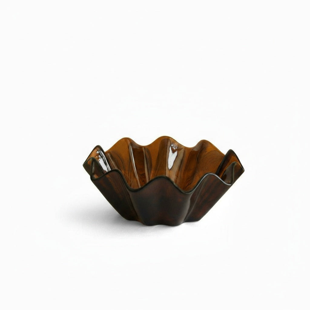 Studio isolation of empty amber glass wavy fruit bowl