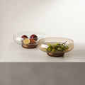 Amber glass fruit bowl with wood base filled with fruit