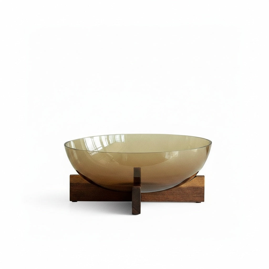 Studio shot of amber glass bowl on wood cross stand