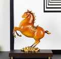 Amber and gold rearing horse sculpture on white background
