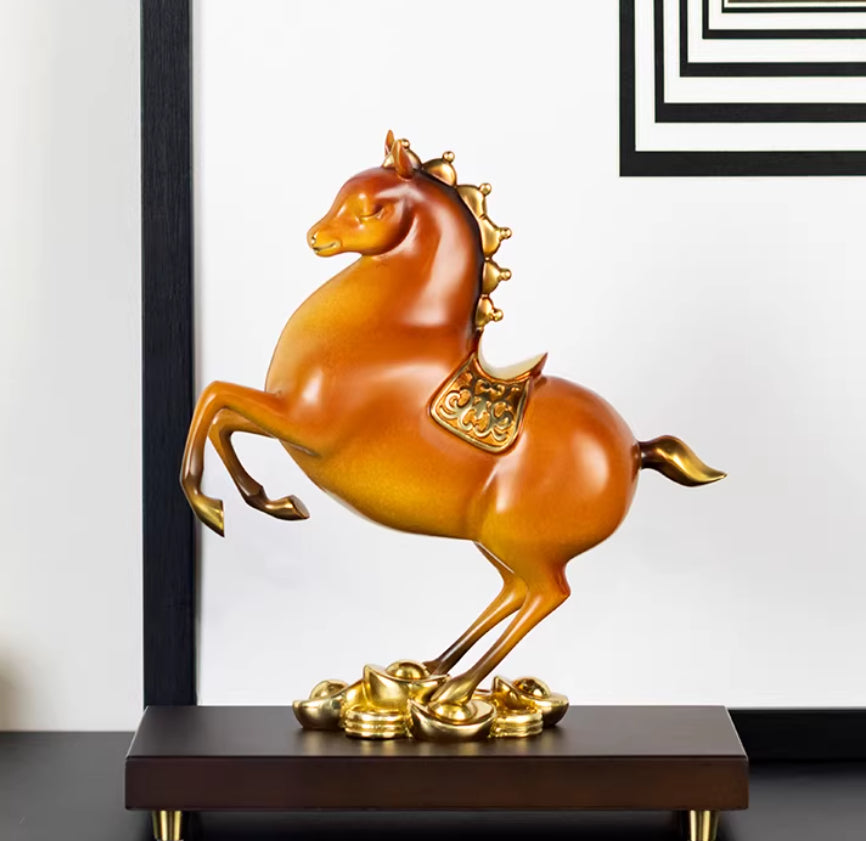 Amber and gold rearing horse sculpture on white background