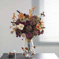 Amber gradient glass vase with floral arrangement on black table
