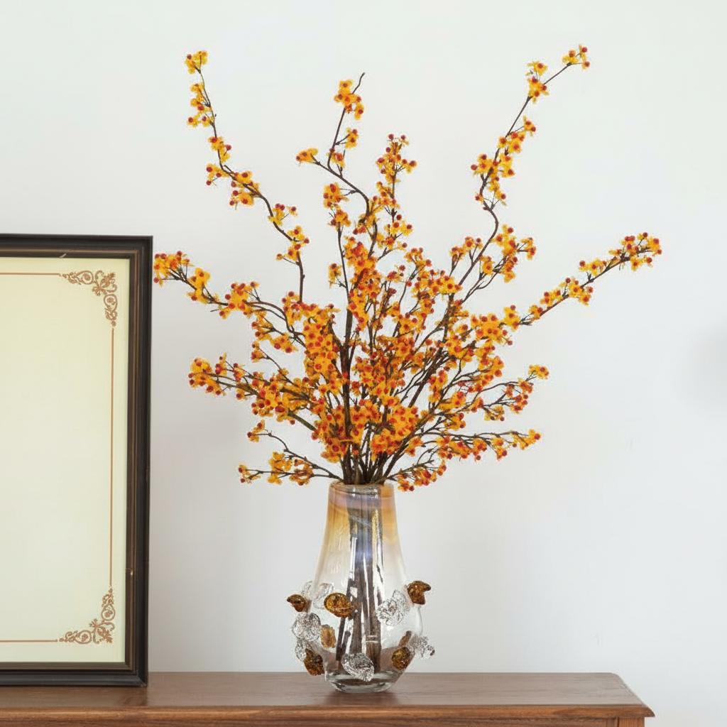 Sculptural glass vase with amber accents holding yellow branches