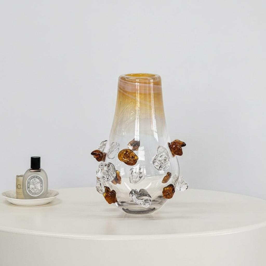 Detail of empty amber and clear glass vase with stone embellishments