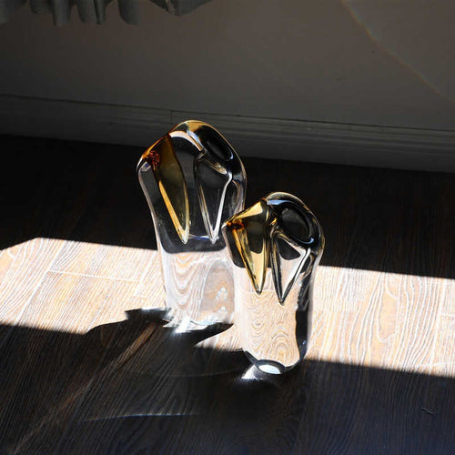 Amber and grey sculptural glass vases on wooden floor