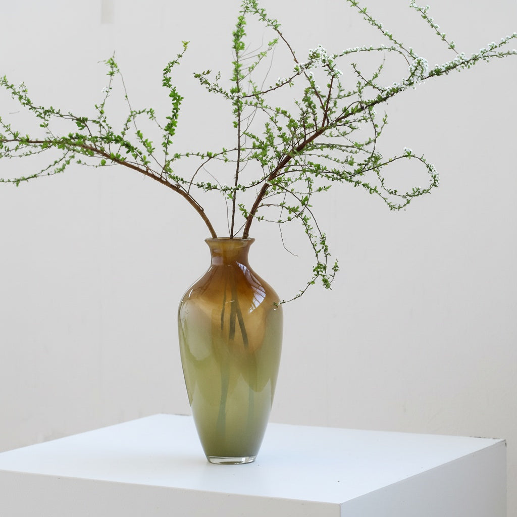 Tall glass vase styled with delicate white flowering branches