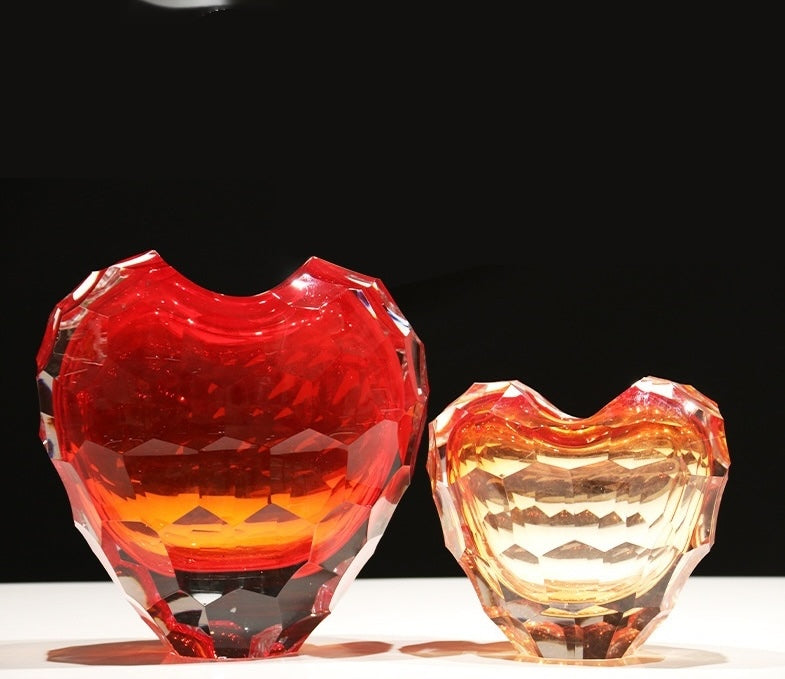 Illuminated crystal heart vases on dark background showing color gradient