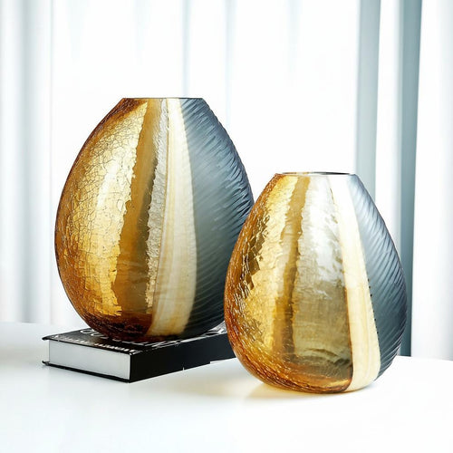 Two amber and smoke textured glass vases on a book