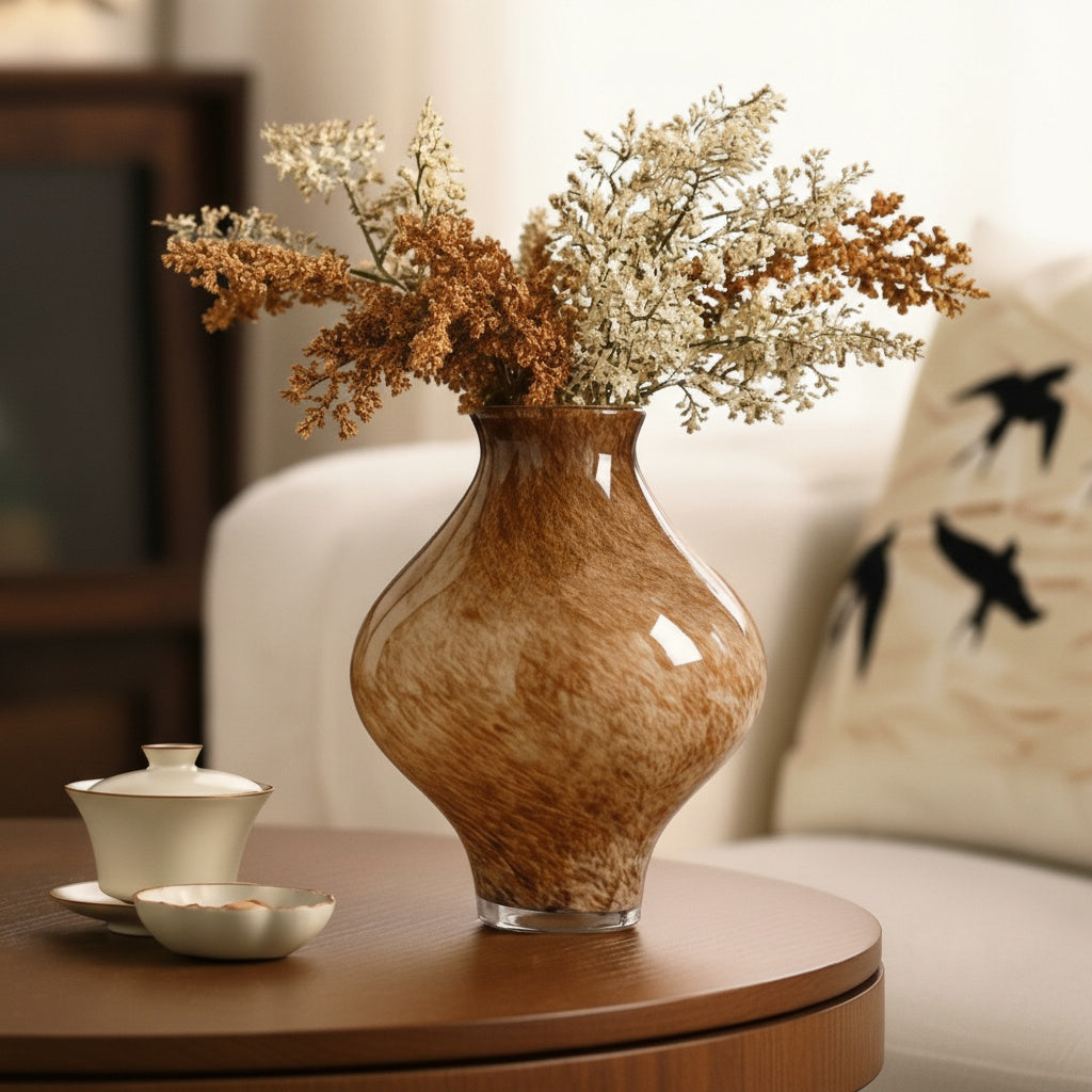 Amber speckled glass bulbous vase with dried flowers on table