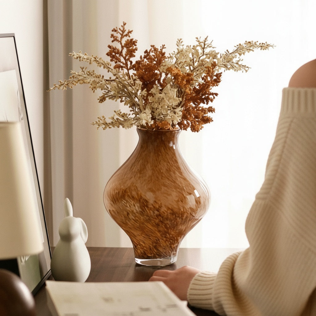 Lifestyle shot of amber vase with person reading nearby
