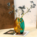Amber and teal bubbled glass vase with dried berries