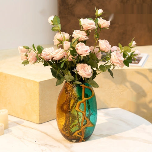 Two tone art glass vase holding pink roses