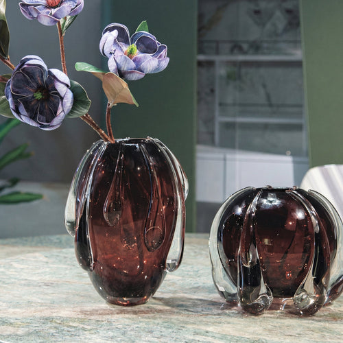 Two brown glass vases on a table with a blurred background