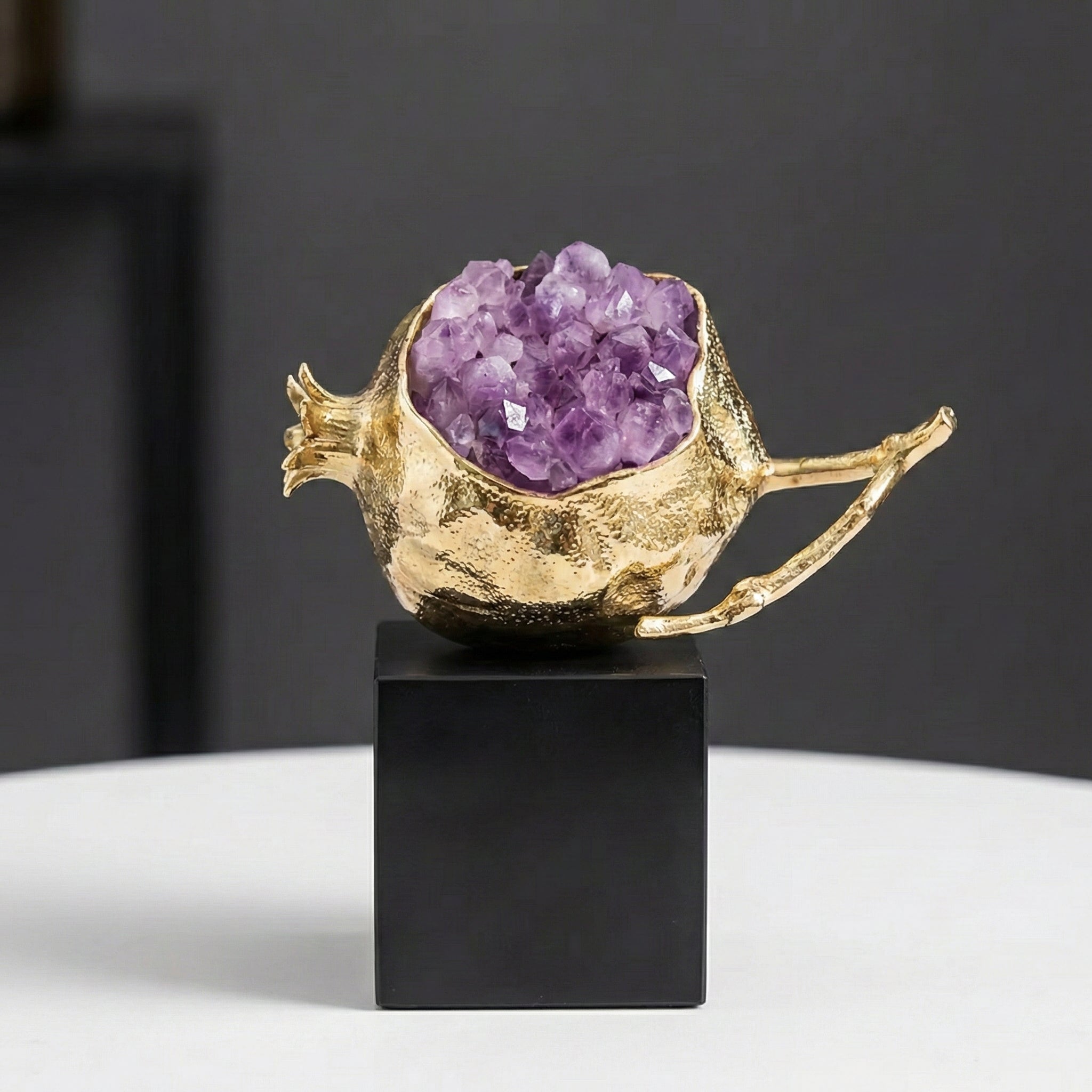 Front view of gold pomegranate sculpture with amethyst crystals