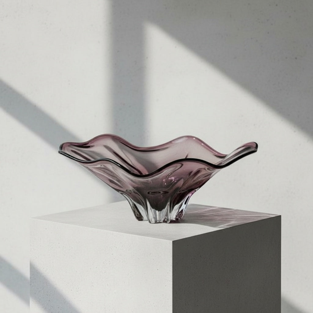 Amethyst art glass bowl displayed on wooden table near window